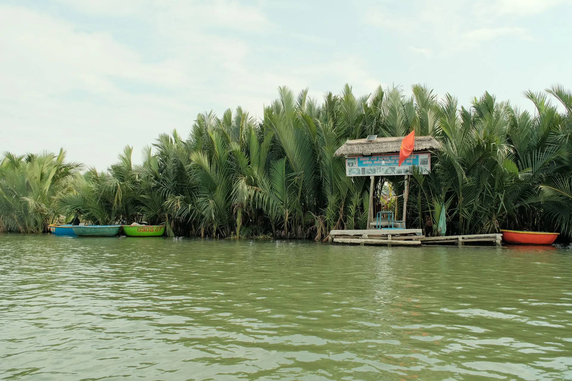 Boats and palms at a riverside landing near Hoi An