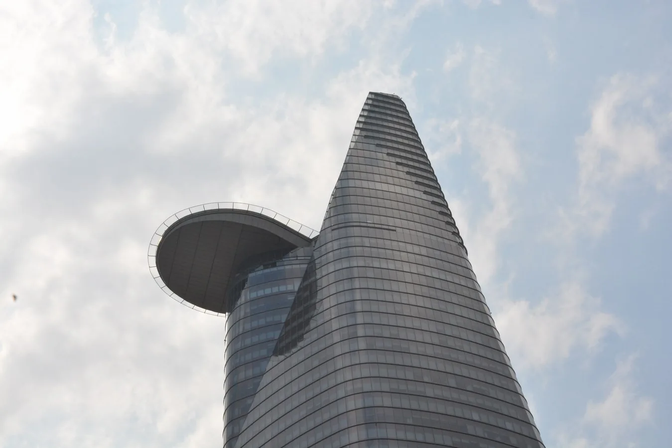 Небоскрёб Bitexco Financial Tower с круглой площадкой на фоне дневного неба в Хошимине
