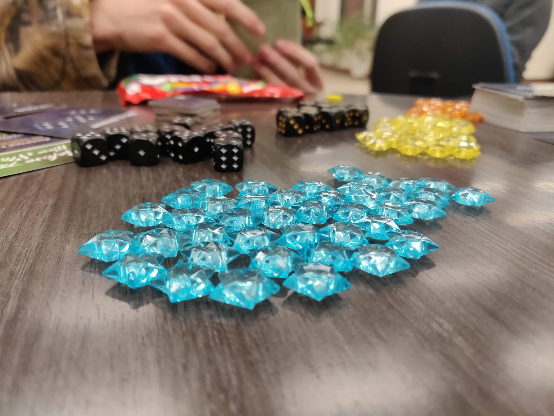 Blue and yellow game pieces, dice and cards on a table