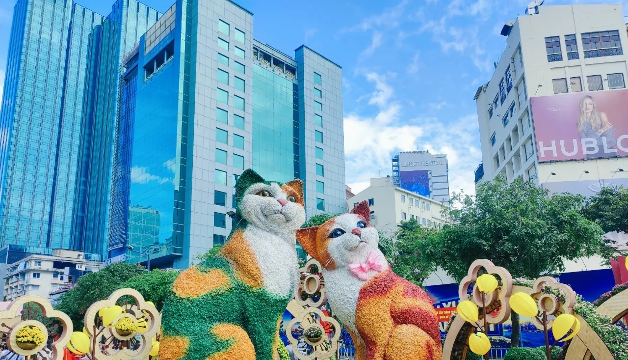 Two large cat figures among flowers and Tet decorations on Nguyen Hue Street in Ho Chi Minh City