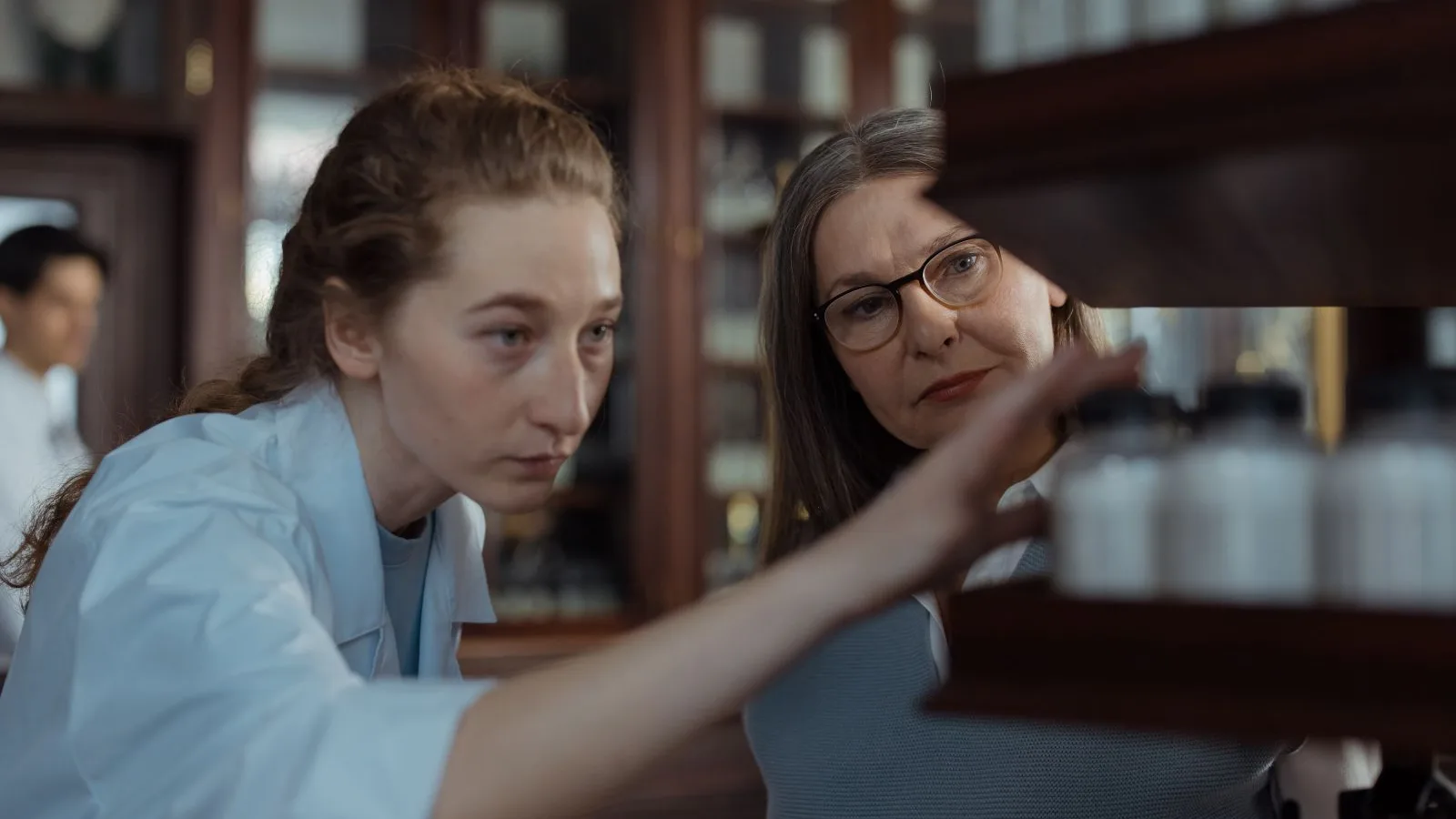 Pharmacists near a shelf with medicine