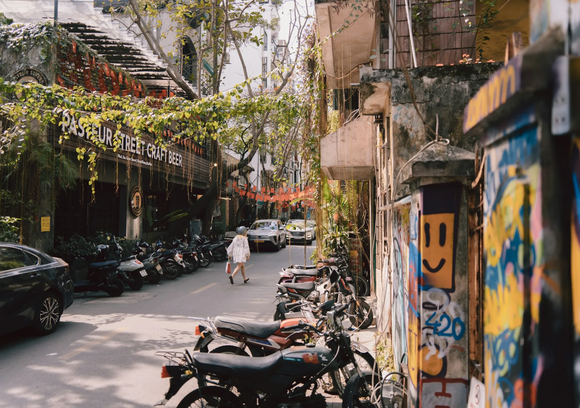 Hanoi street with parked motorbikes and a pedestrian